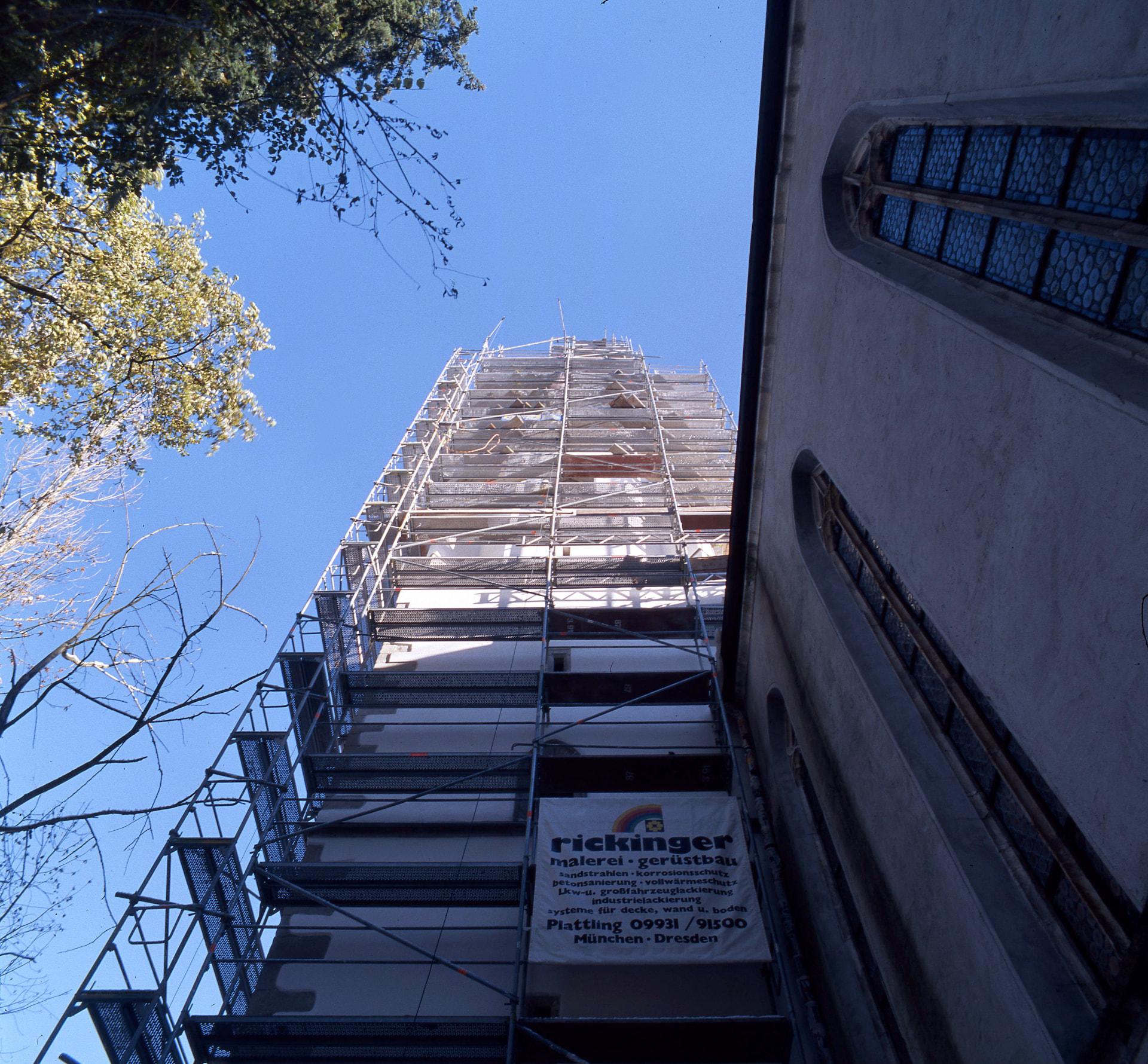 Eingerüsteter Kirchturm mit Rickinger-Banner während der Sanierung