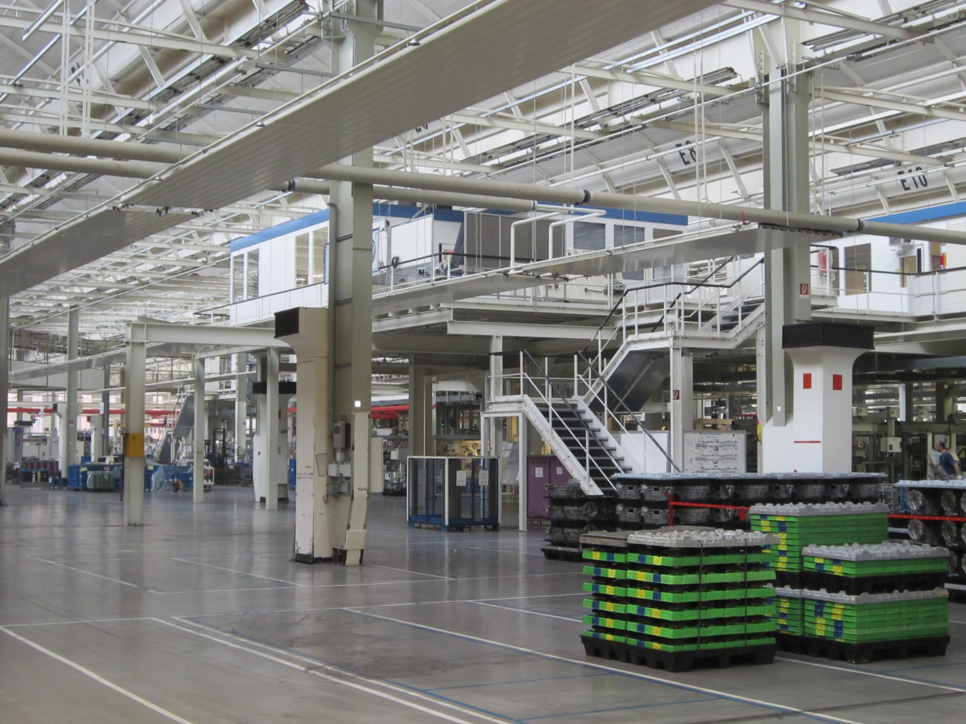Große Fertigungshalle mit weiß gestrichener Stahlkonstruktion und Bodenmarkierung
