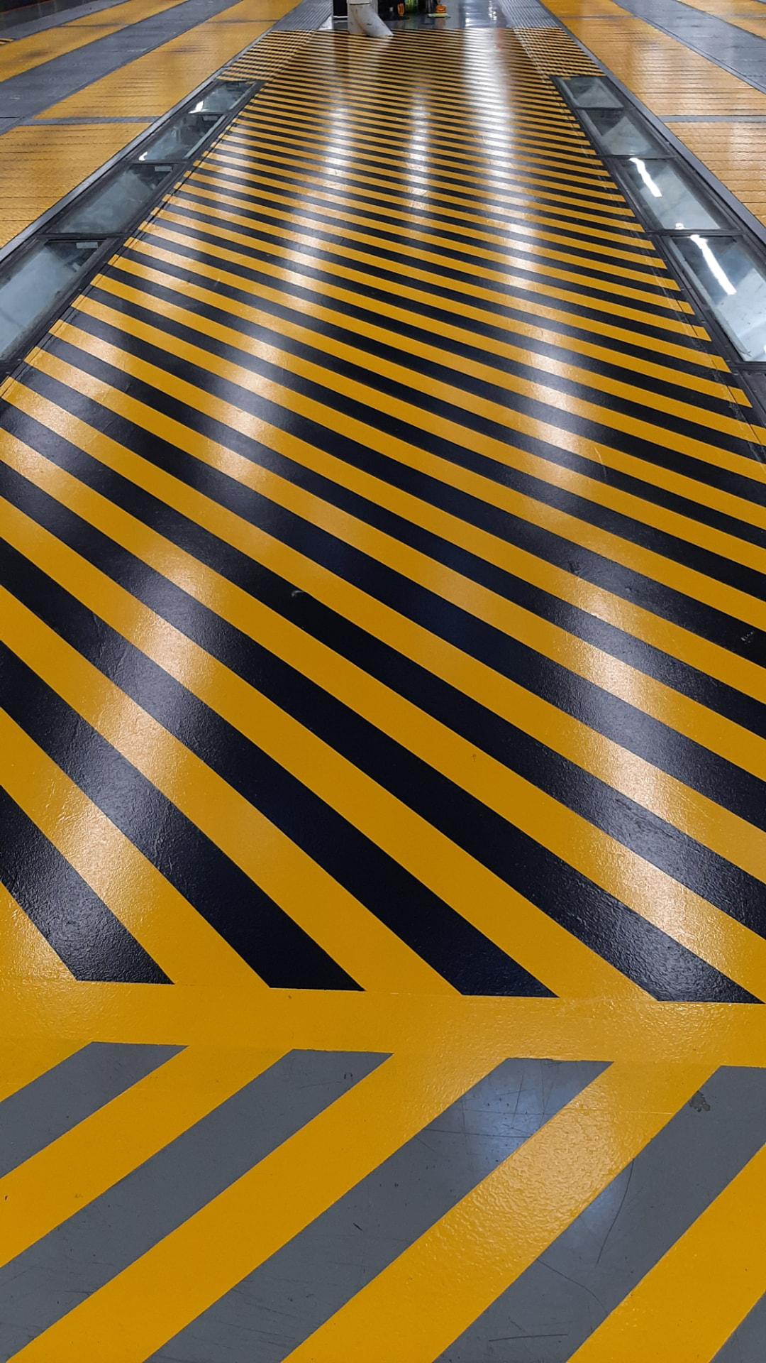 Gelb-schwarze Warnmarkierung auf einem Hallenboden