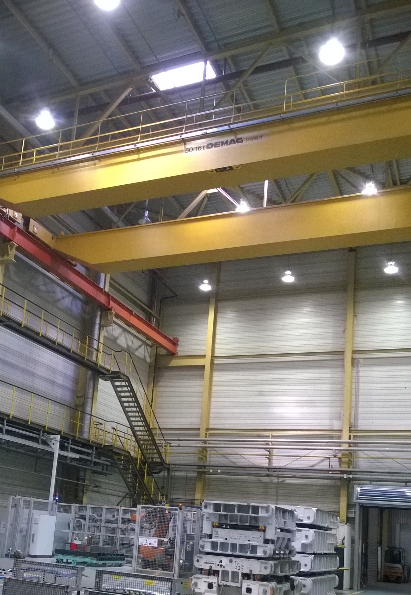 Industriehalle mit gelbem Brückenkran und beschichteten Stahlträgern